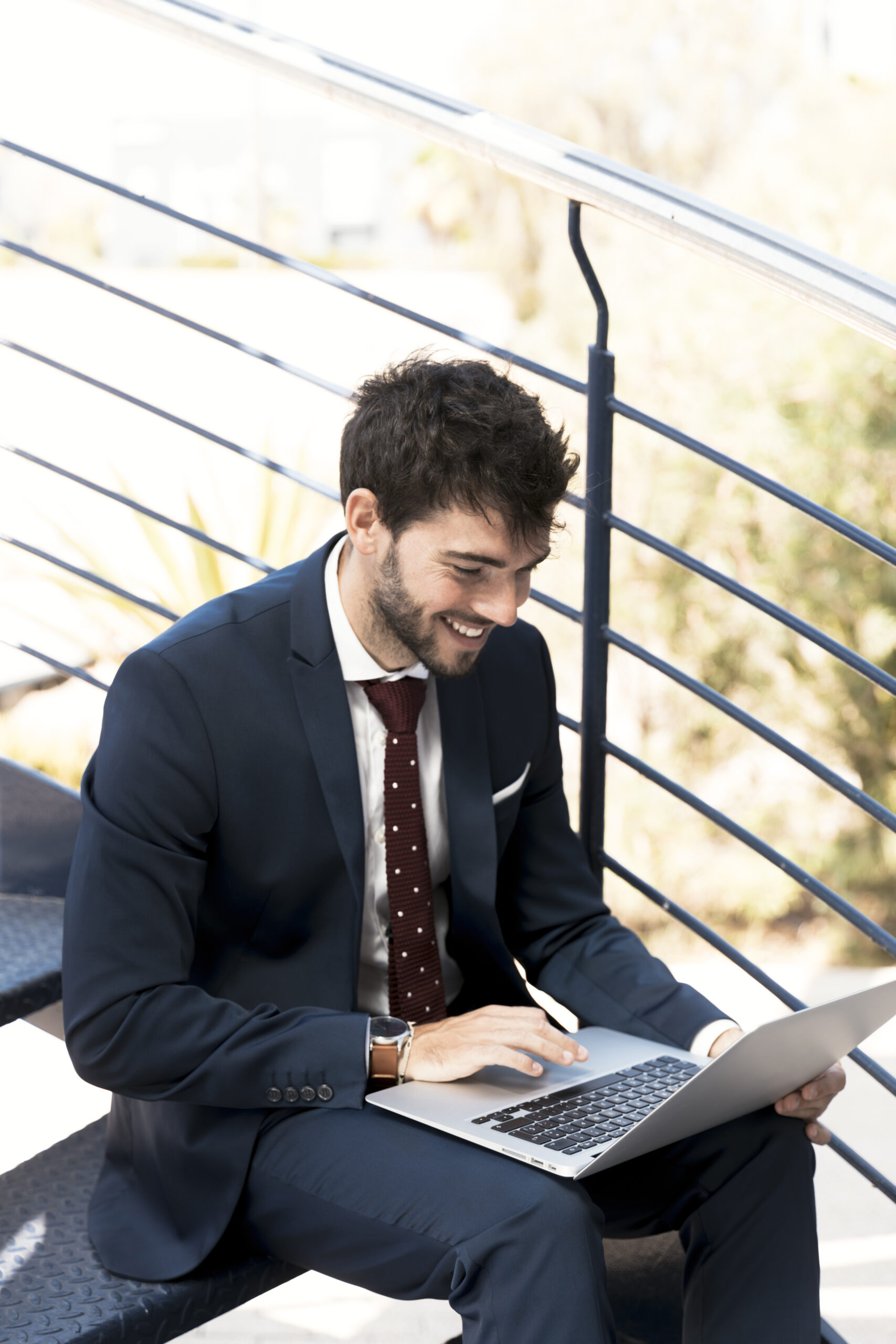 high-angle-happy-man-stairs-with-laptop